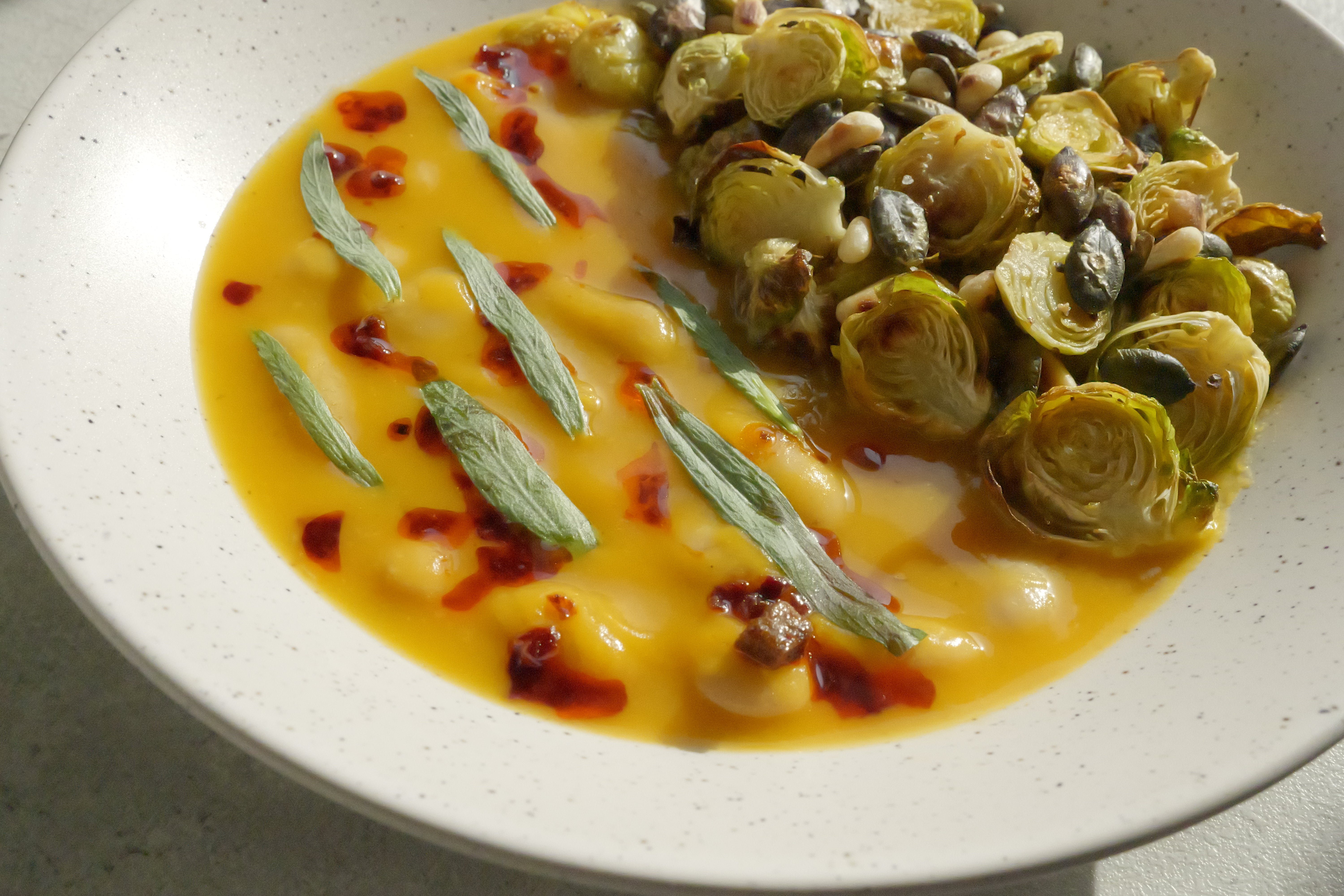 Image of Butternut Squash Brothy Beans with Crispy Brussels Sprouts, Estragon, Szechuan Chili Oil & Toasted Seeds