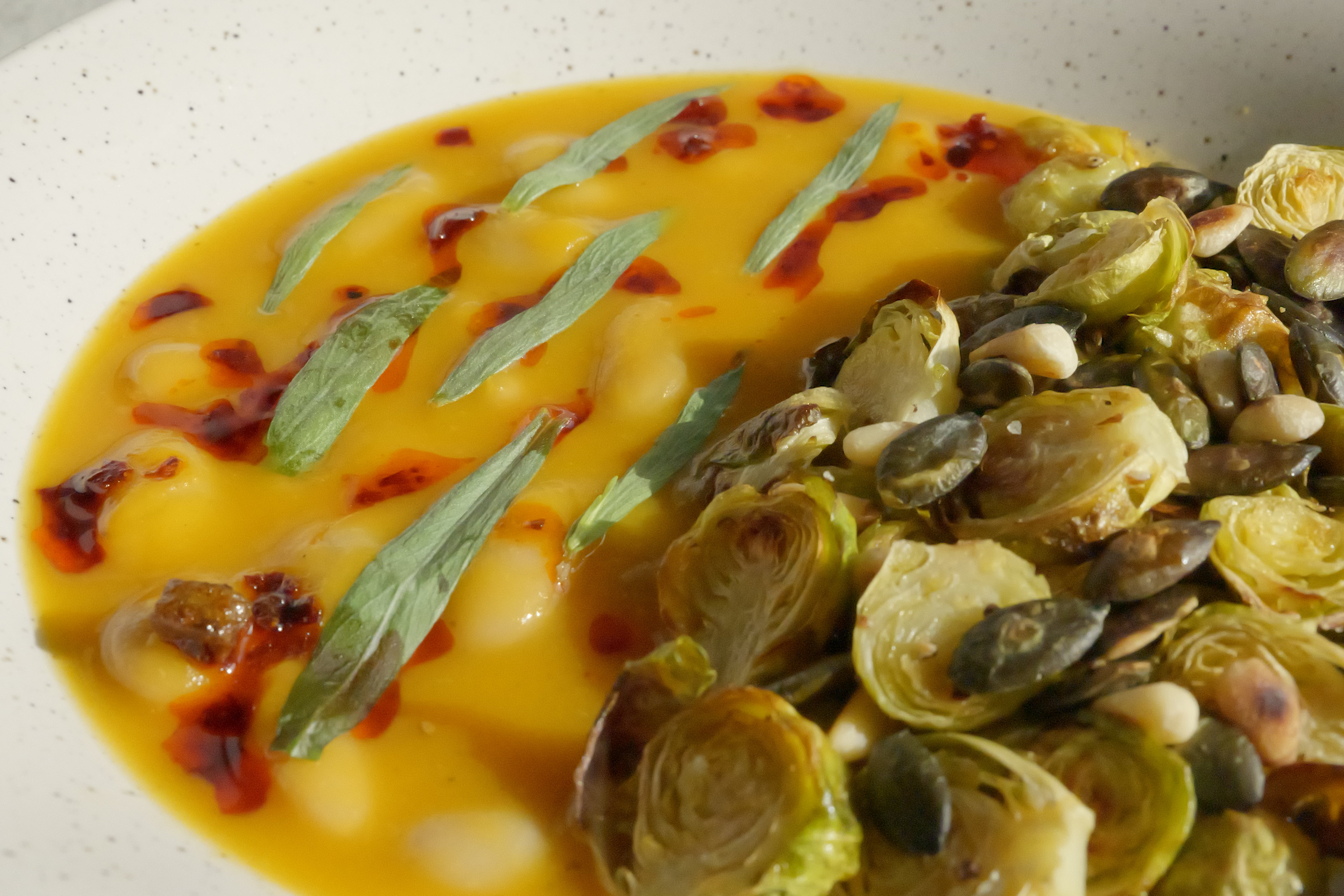 Image of Butternut Squash Brothy Beans with Crispy Brussels Sprouts, Estragon, Szechuan Chili Oil & Toasted Seeds