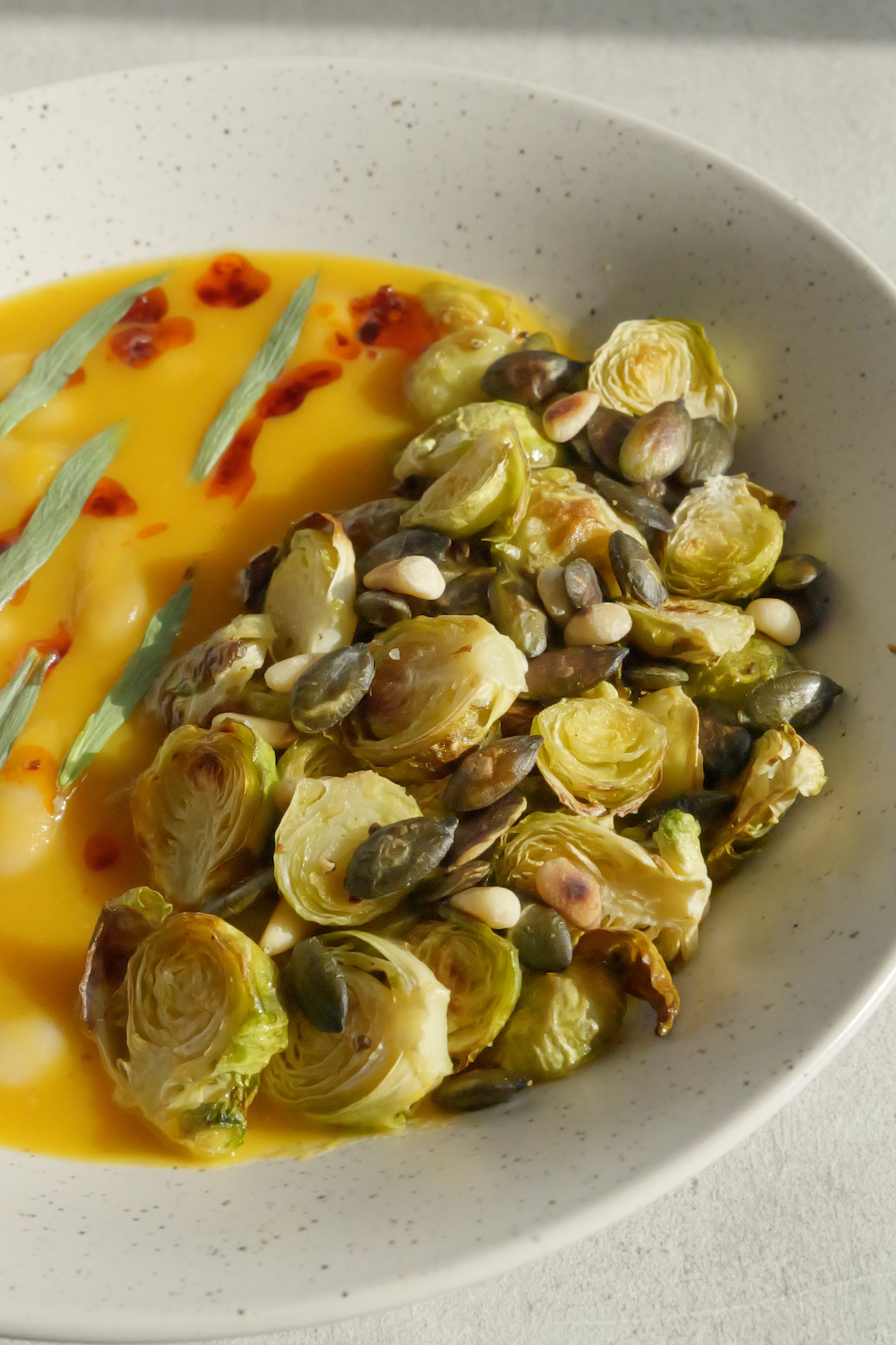 Image of Butternut Squash Brothy Beans with Crispy Brussels Sprouts, Estragon, Szechuan Chili Oil & Toasted Seeds