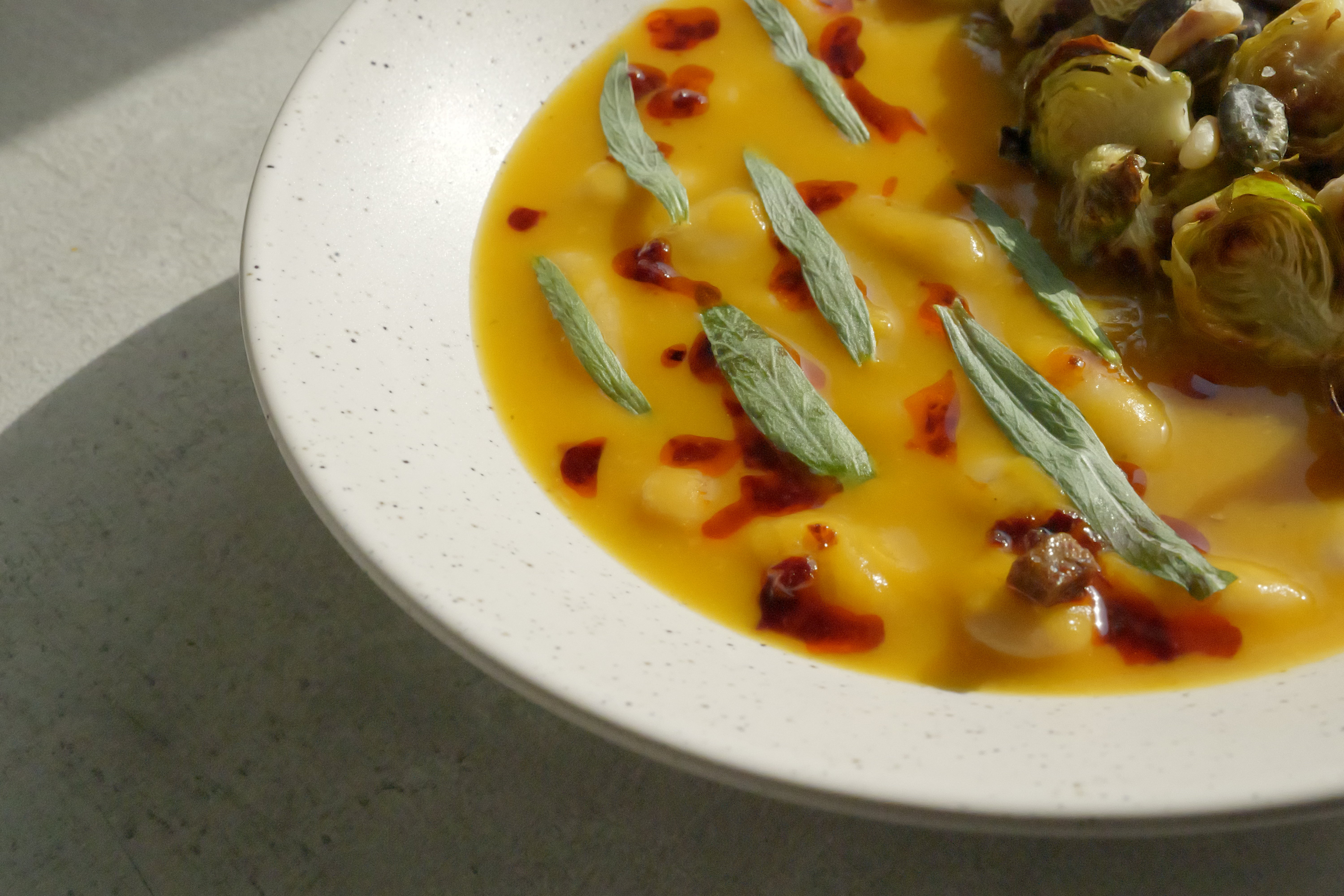 Image of Butternut Squash Brothy Beans with Crispy Brussels Sprouts, Estragon, Szechuan Chili Oil & Toasted Seeds