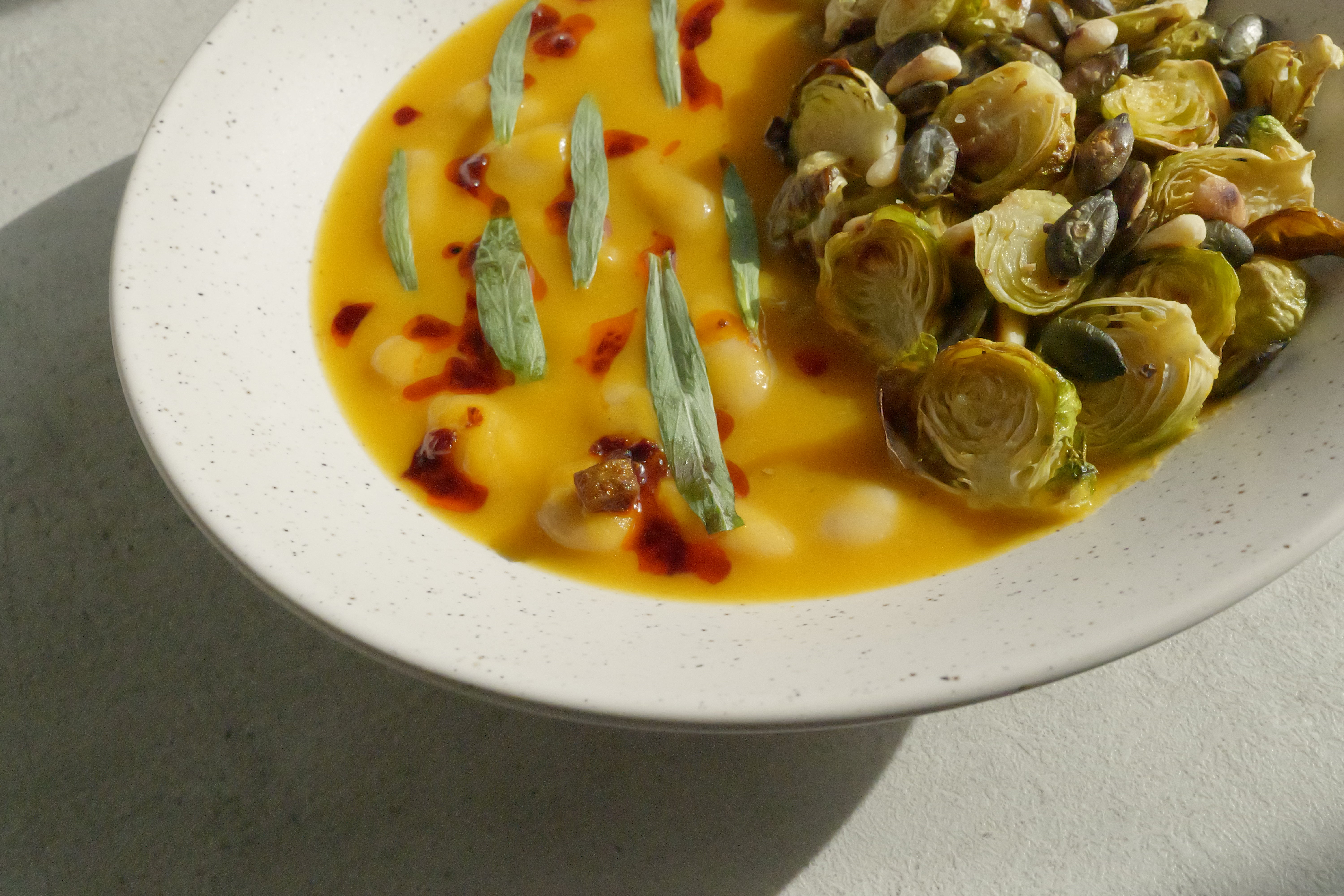 Image of Butternut Squash Brothy Beans with Crispy Brussels Sprouts, Estragon, Szechuan Chili Oil & Toasted Seeds
