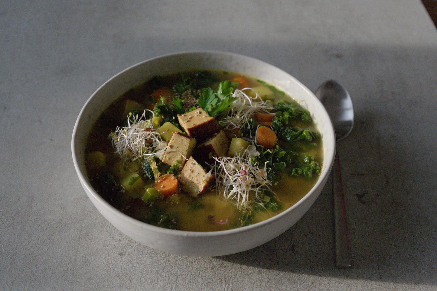 Golden Turmeric Kale Soup with Sesame Smoked Tofu and Sprouts