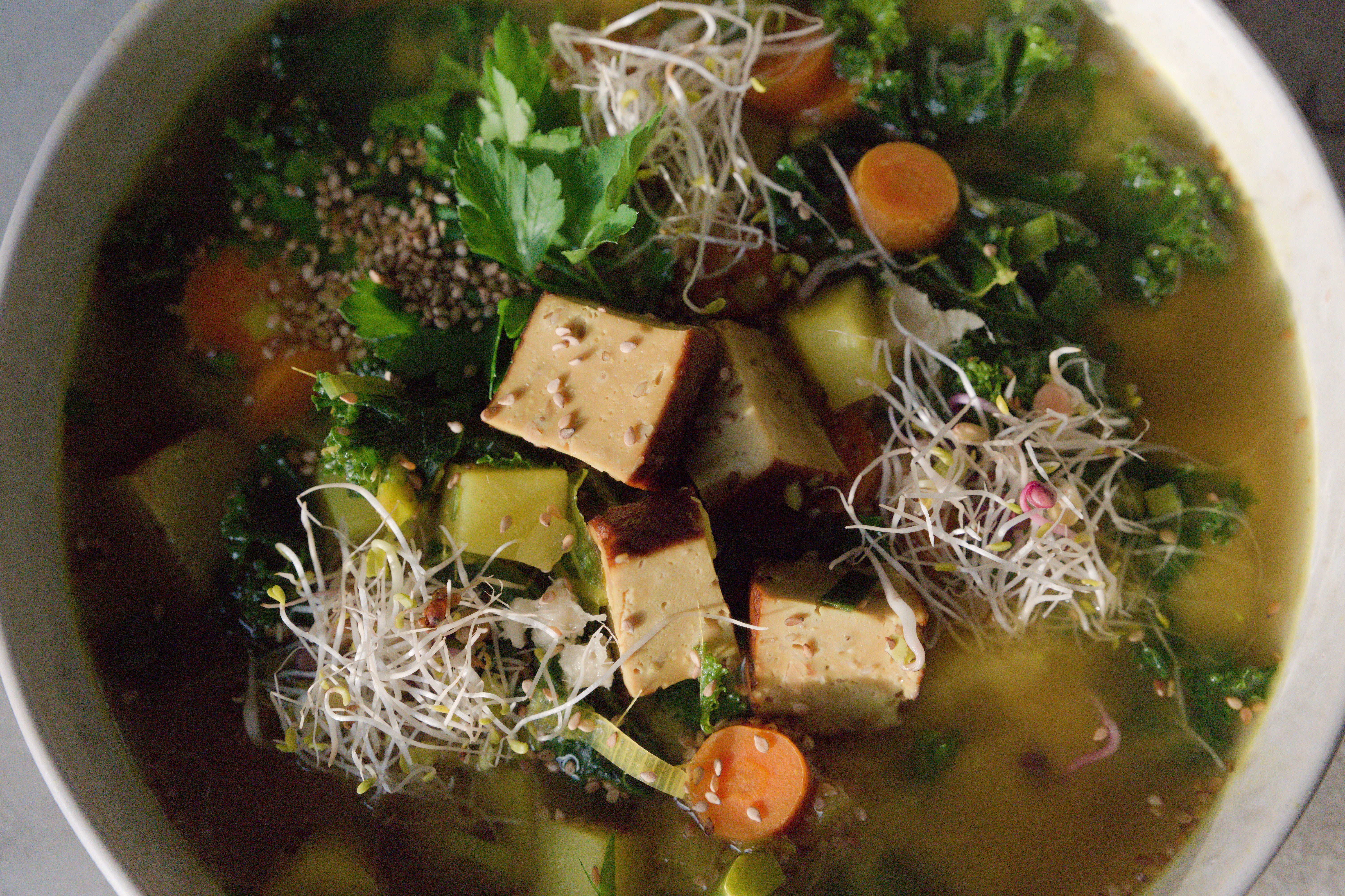 Image of Golden Turmeric Kale Soup with Sesame Smoked Tofu and Sprouts